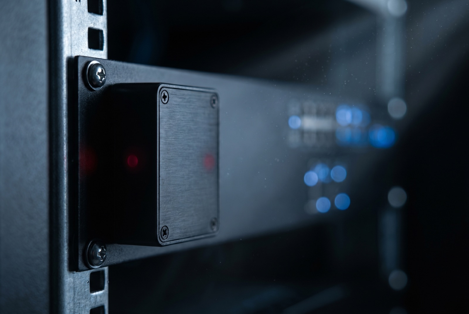 Macro detail of an AMCORN IoT environmental sensor mounted beside live data centre equipment